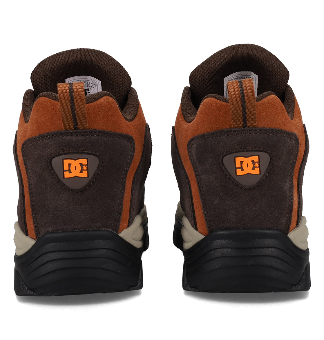 A pair of Men’s Recon OG Shoes by DC Shoes is displayed side by side on a white background, showcasing their brown and orange colorway with black and beige soles. The DC logo appears on the heel, emphasizing the shoes’ sturdy build and urban style.