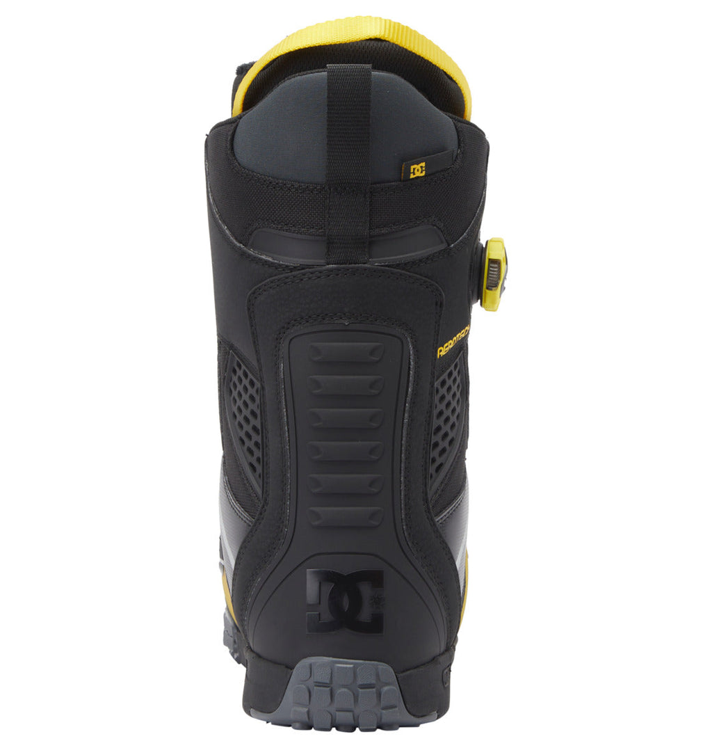Rear view of the DC Shoes Men’s Phantom BOA® Snowboard Boots in black and yellow, featuring a textured sole, padded ankle support, DC logo on the heel, and a BOA® Fit System dial visible on the right. These boots are also equipped with PrimaLoft insulation for enhanced warmth and comfort during cold days.