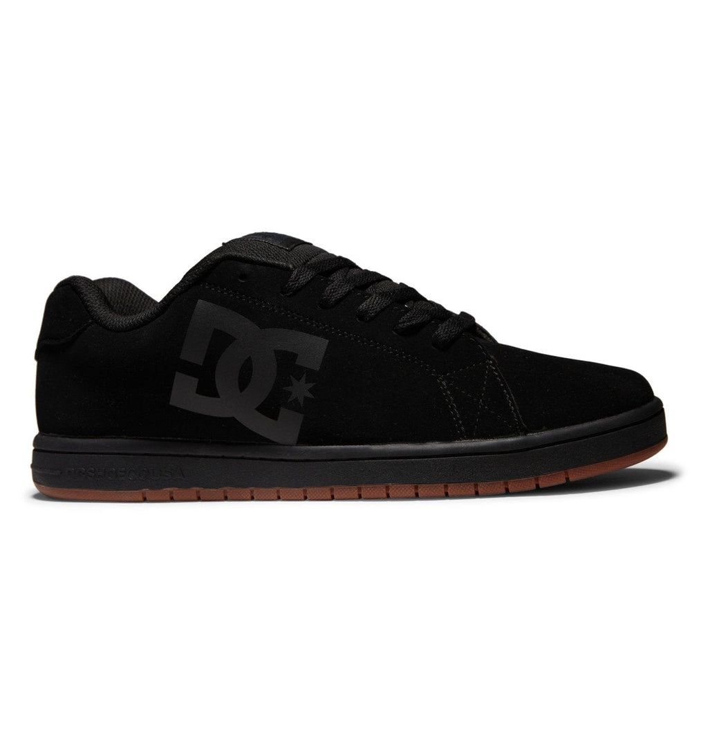 The Men’s Gaveler Shoes by DC Shoes feature a sleek black leather upper paired with a black sole and brown rubber bottom. These chunky, low-top skate shoes are designed for durability, include black laces, and showcase the iconic DC logo on the side.