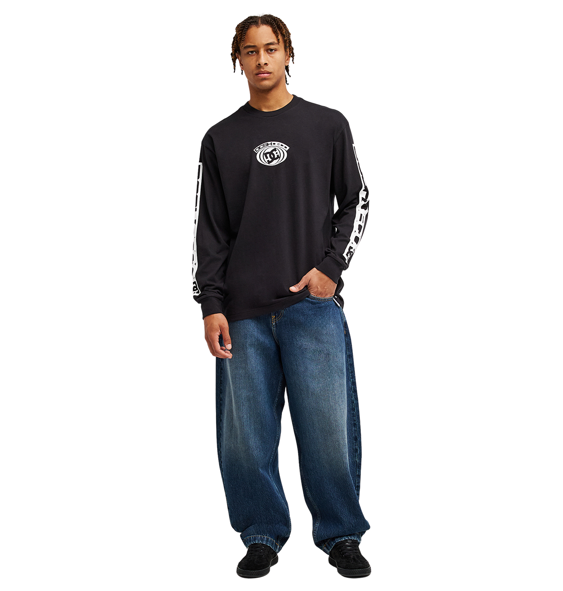 A person stands facing forward against a plain white background, wearing the Men's DC Echo Tee by DC Shoes—a black long-sleeve graphic tee featuring bold white DC-style graphics on the sleeves and chest—paired with loose blue jeans and black shoes, ready for casual skate sessions.